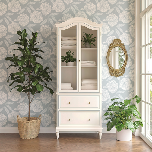 White cabinet with glass doors, decorative mirror, and potted plants against floral wallpaper.