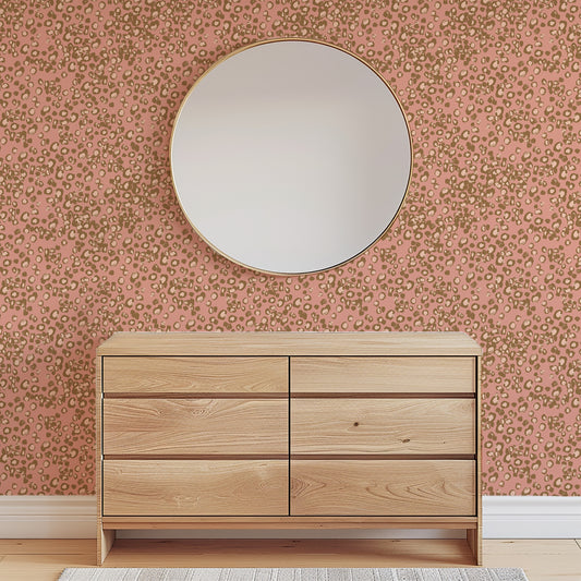 Wooden dresser with a round mirror against a patterned wall.