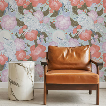 Brown leather armchair in front of floral wallpaper