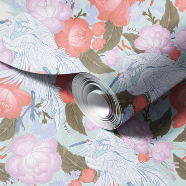 Roll of floral-patterned paper with peacocks and flowers on a light blue background