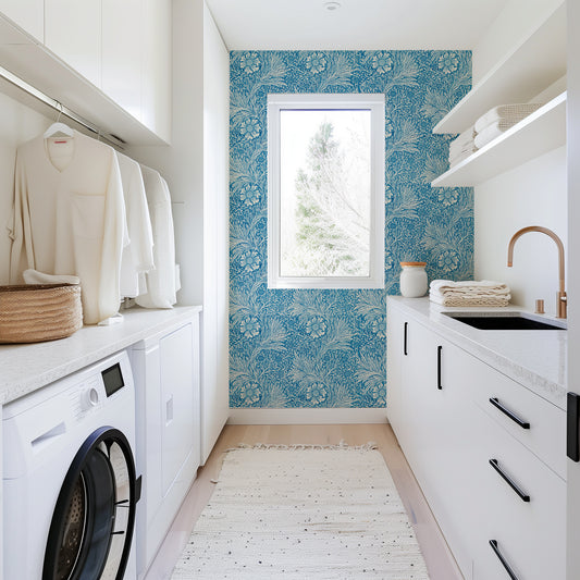 Modern laundry room with blue floral wallpaper, white cabinets, and washing machine.