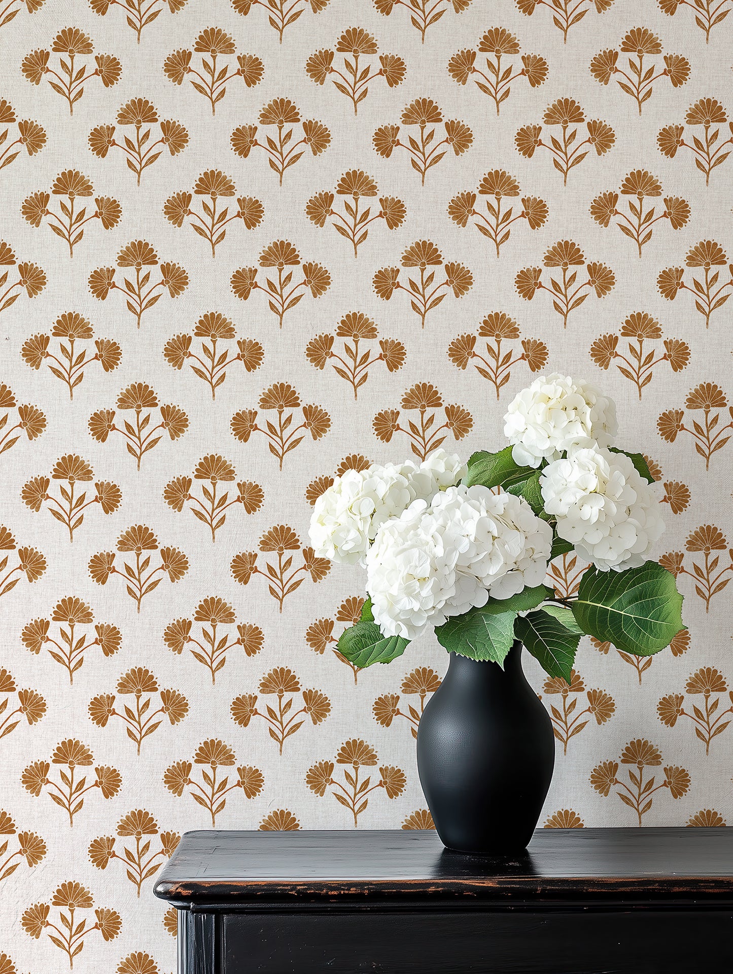 Vase with white flowers on a table against a floral wallpaper background