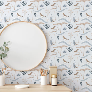Wallpaper with nature-themed design featuring birds and plants, with a wooden frame and decor items on a table.