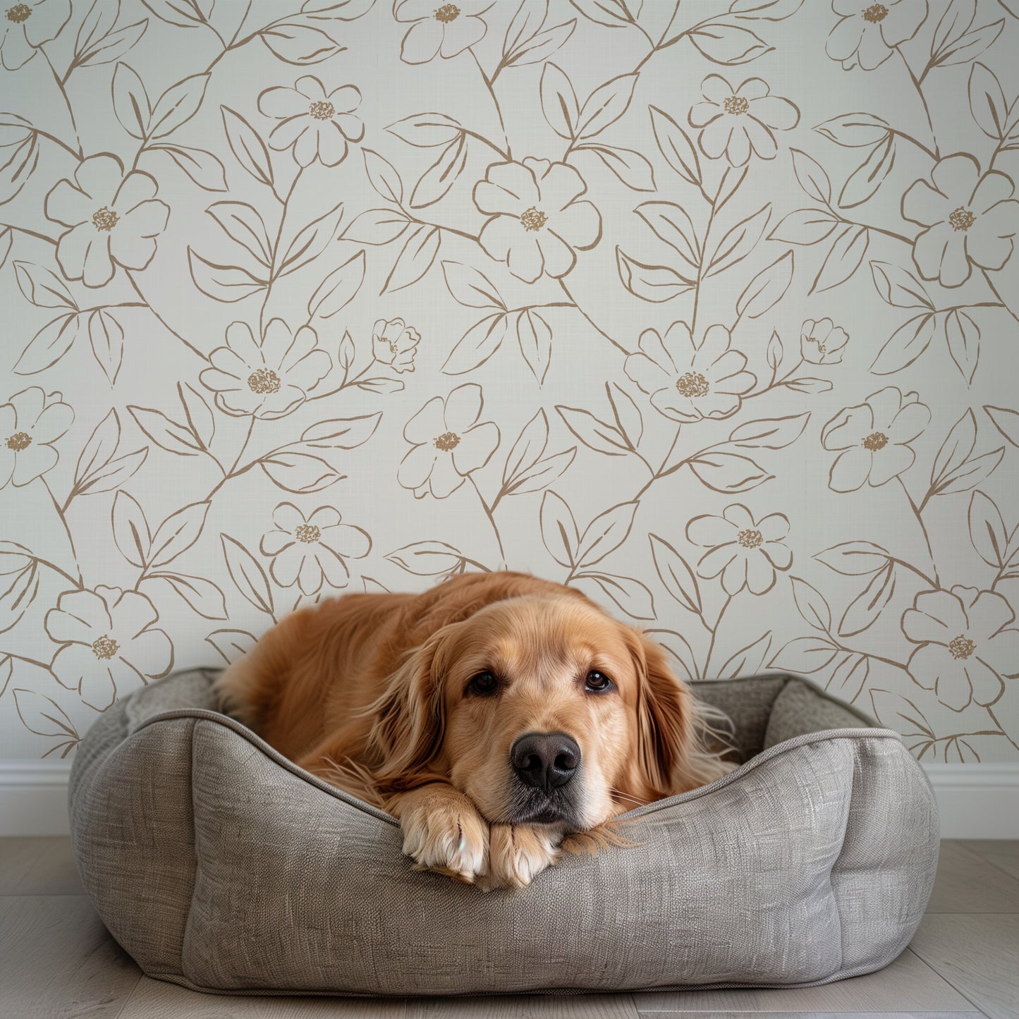 Dog lying on a gray pet bed against a floral wallpapered wall.