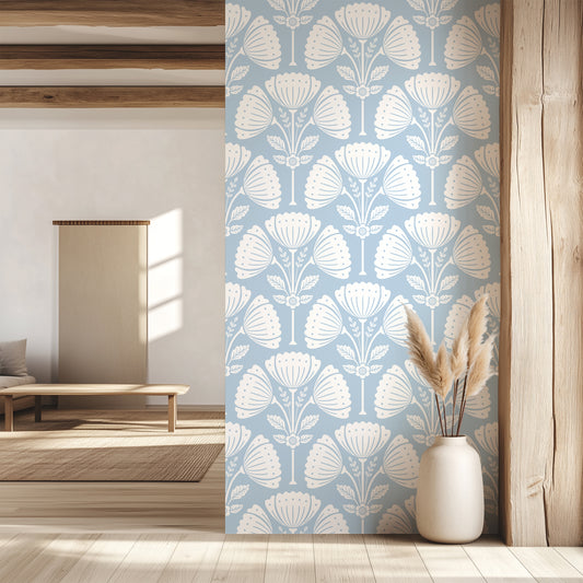 Room interior with floral wallpaper, wooden floor, and vase with dried plants.