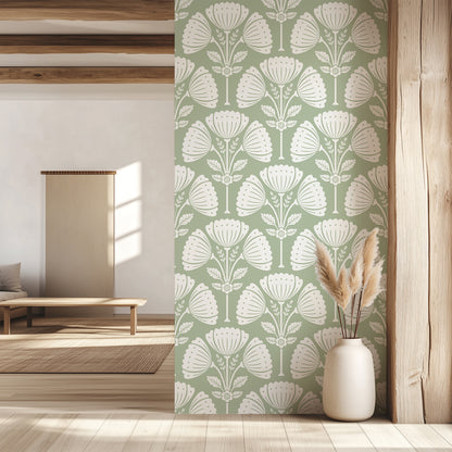 Room interior with a green and white floral patterned wall, a vase with dried plants, and wooden furniture.