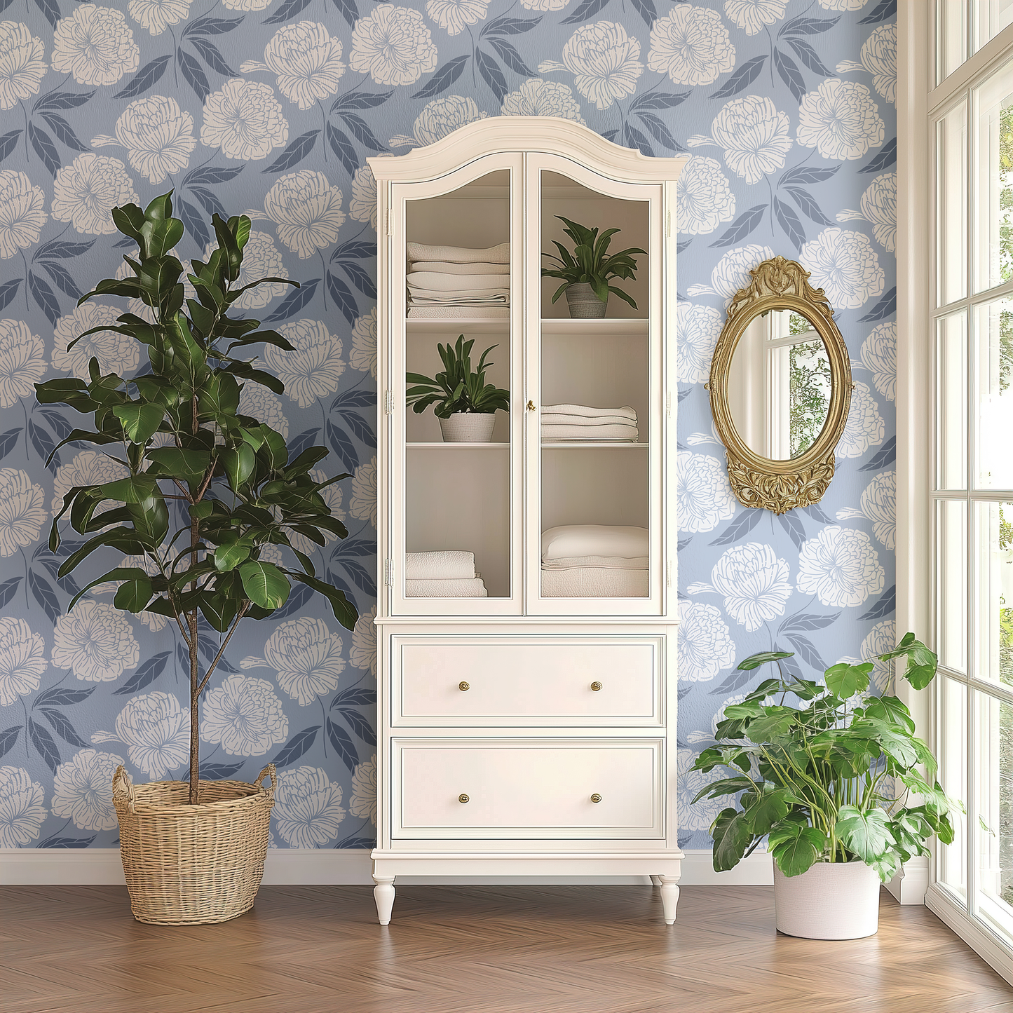 White cabinet with glass doors against a floral wallpaper wall, with plants and a mirror.