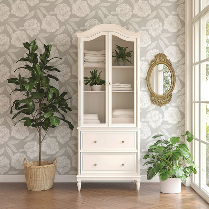 White cabinet with glass doors, plants, and a decorative mirror in a room with floral wallpaper.