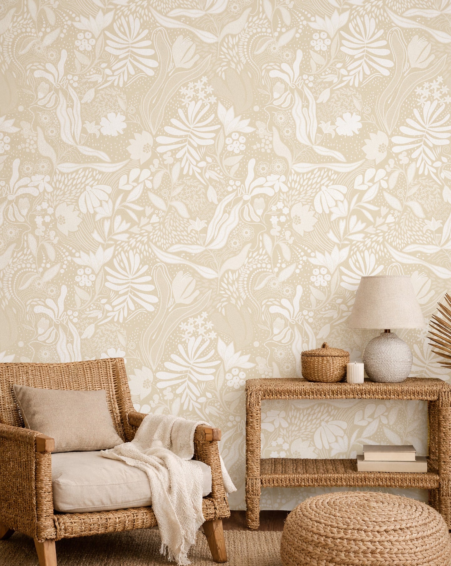 Living room with wicker chair, side table, and ottoman against a floral wallpaper.