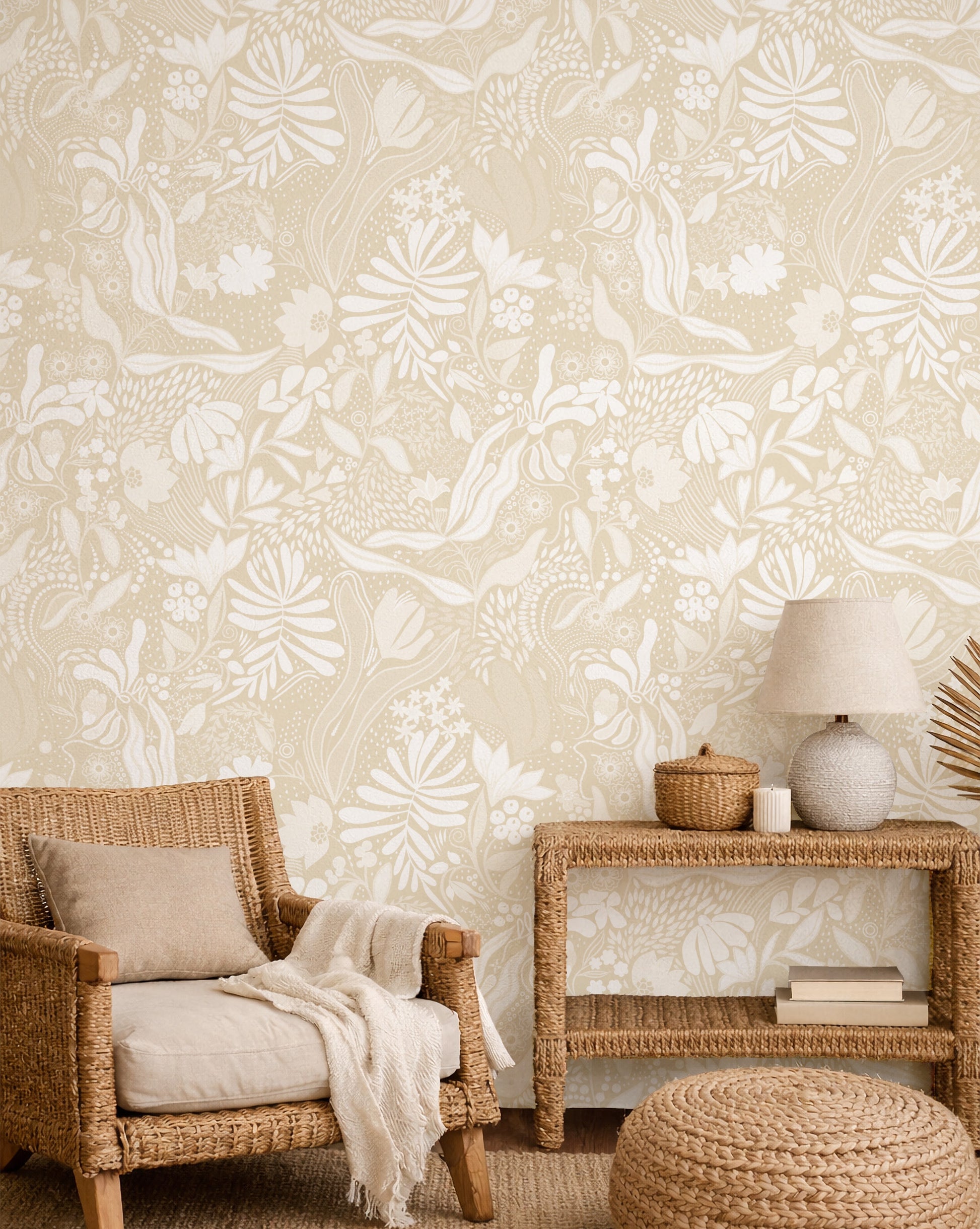 Living room with wicker chair, side table, and ottoman against a floral wallpaper.