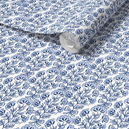 Roll of fabric with blue floral pattern on a white background