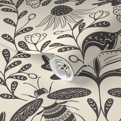 Roll of wallpaper with black floral and bee pattern on a beige background