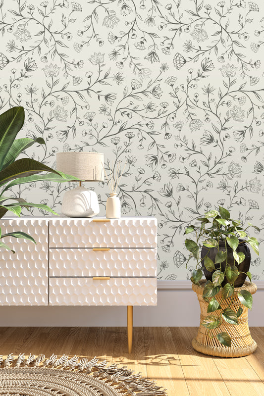 White textured dresser with decorative items against a floral wallpapered wall.