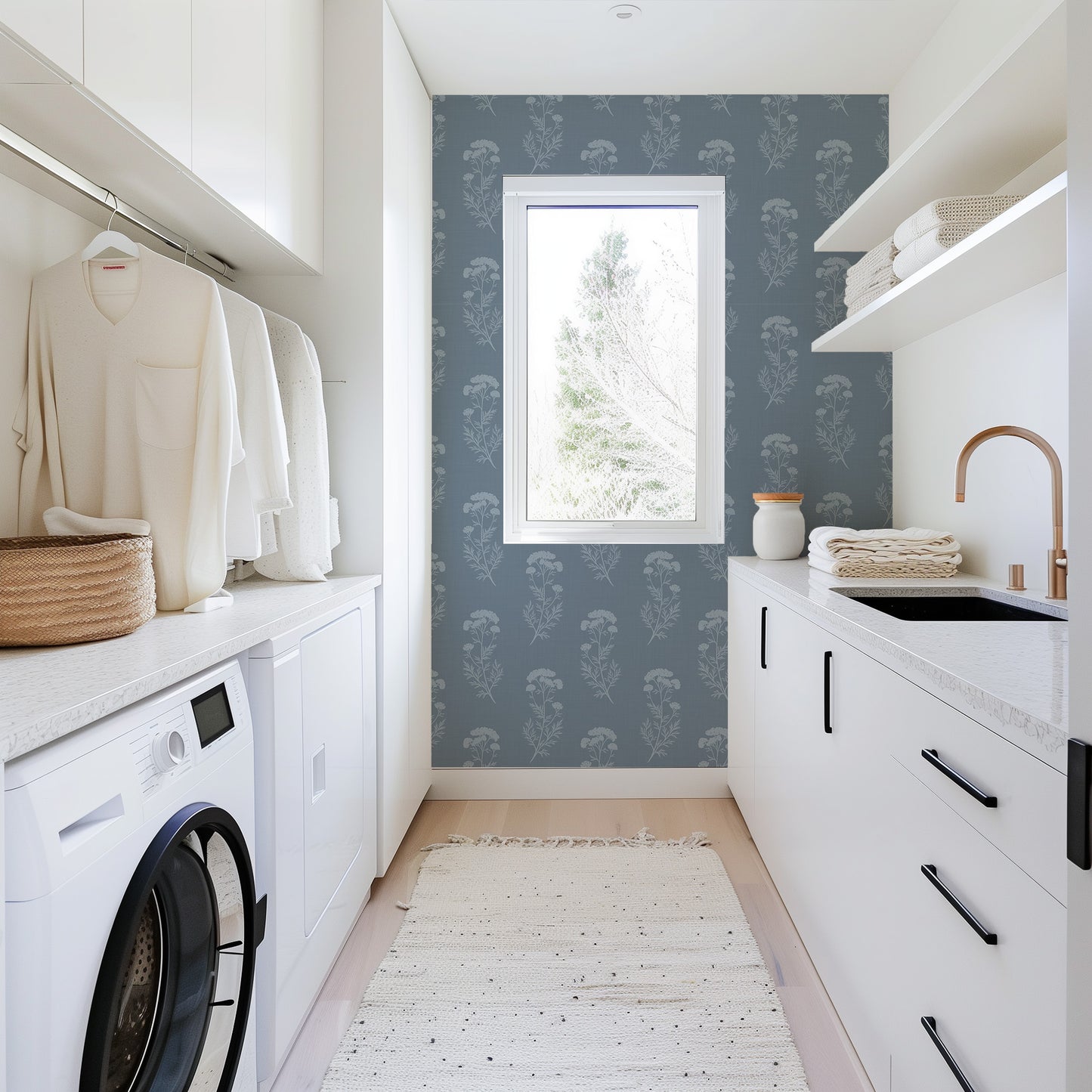 Modern laundry room with washing machine, dryer, and sink area.