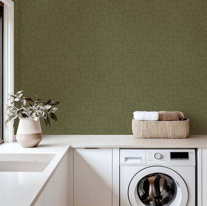 Laundry room with green wallpaper, white washing machine, and a basket of clothes.