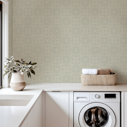 Laundry room with washing machine, basket of clothes, and plant against a patterned wall.