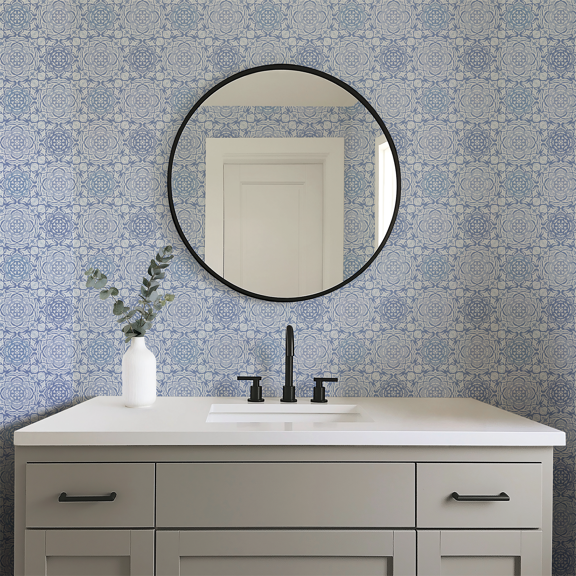 Bathroom vanity with round mirror and patterned blue tiles