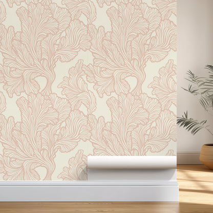 Roll of pink floral wallpaper on a neutral wall with a plant in the corner.