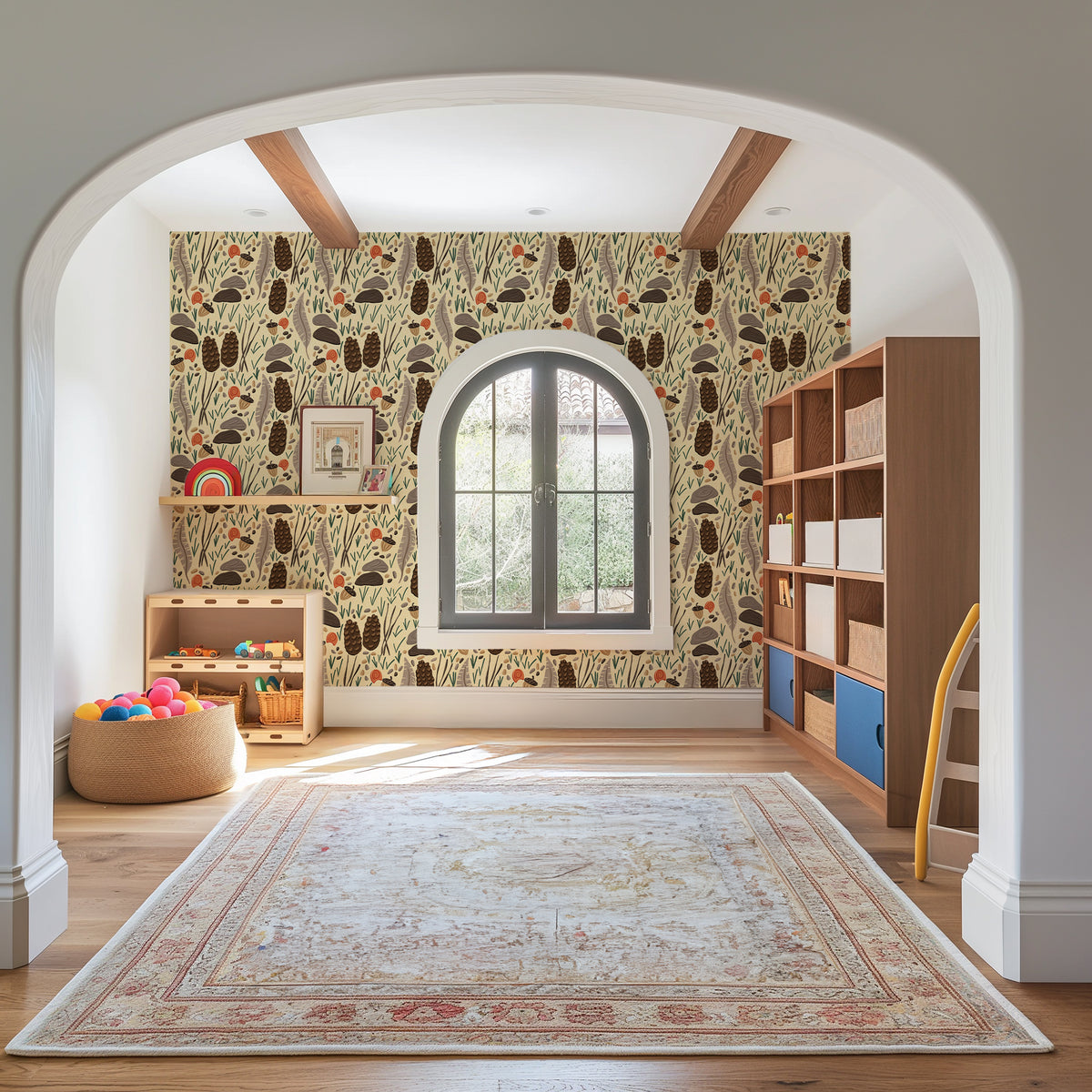 A styled children's room interior viewed through a white arched doorway, featuring a wall covered in a whimsical botanical patterned wallpaper. The wallpaper has a cream background with brown, black, and muted green tree and leaf motifs.