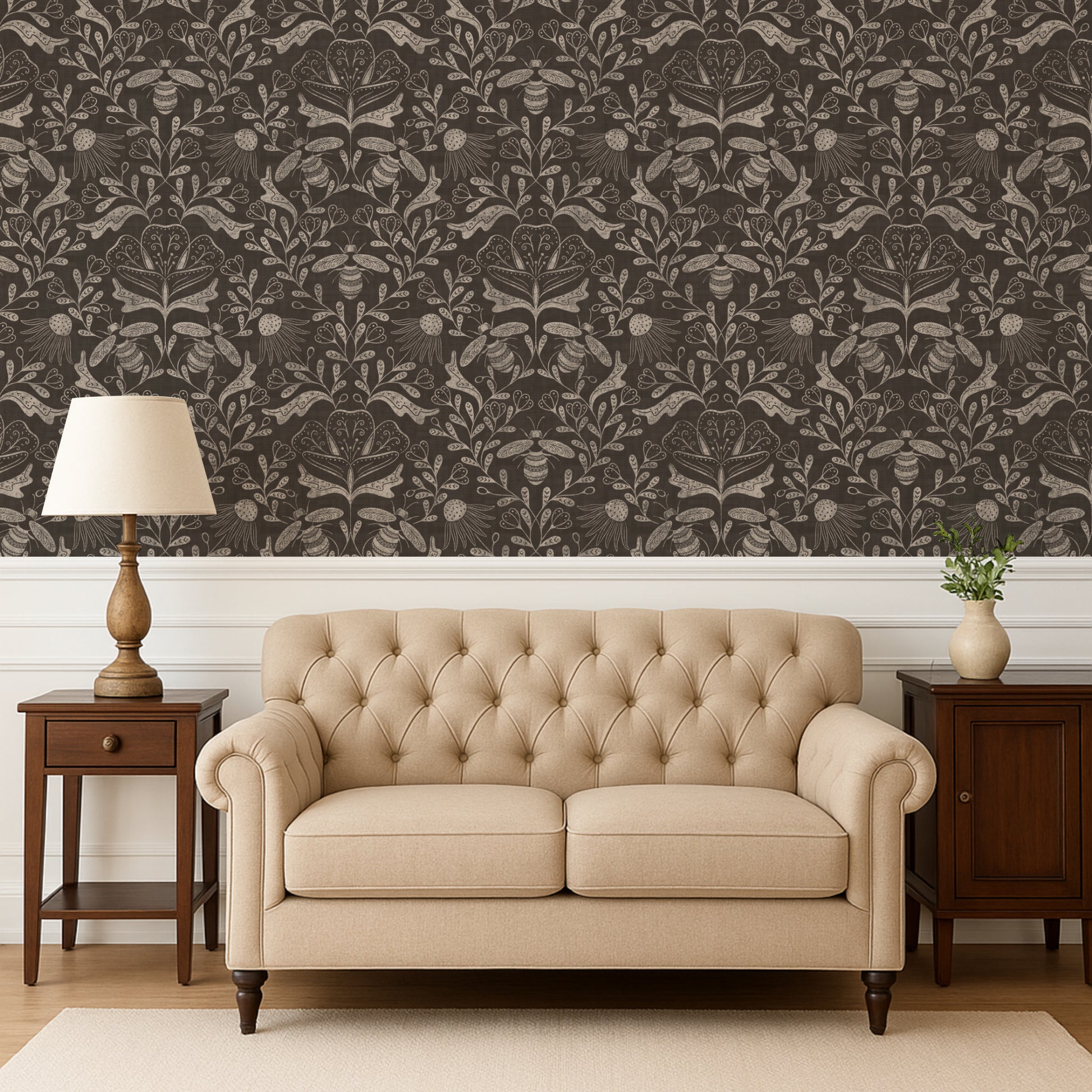Beige tufted sofa in a room with patterned wallpaper and wooden furniture.