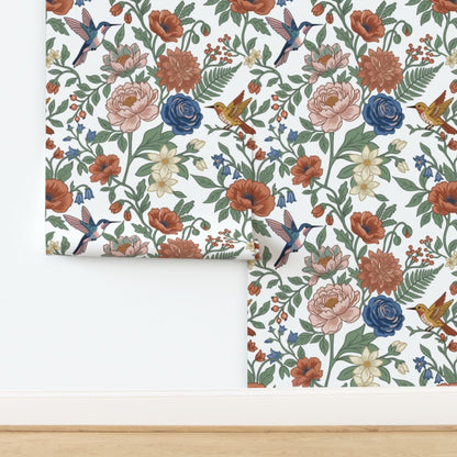 Whimsical Hummingbird Garden peel and stick wallpaper with colorful flowers and hummingbirds being installed on a blank wall
